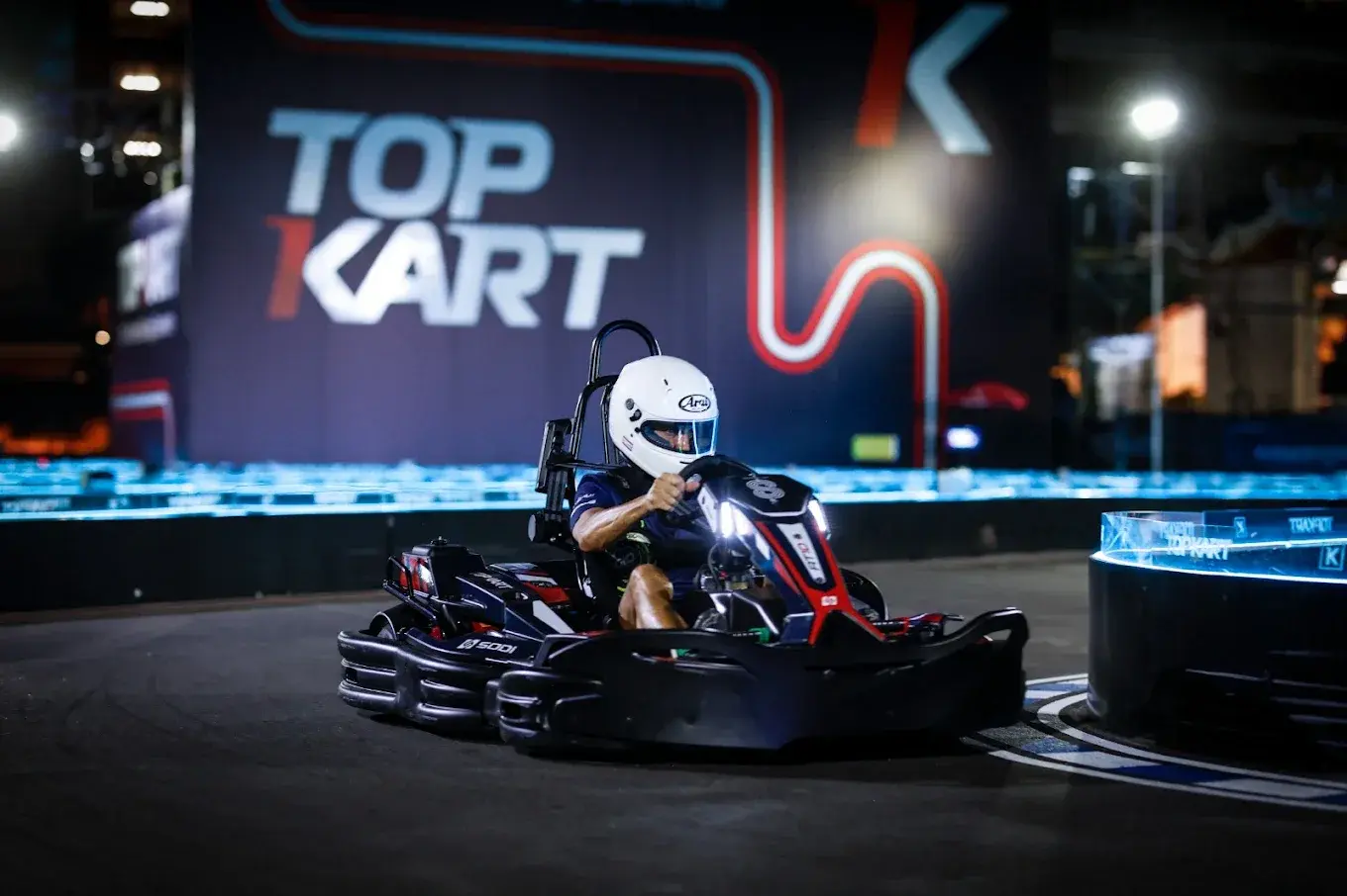 Helmeted driver racing a SODI go-kart at Top Kart Bangkok