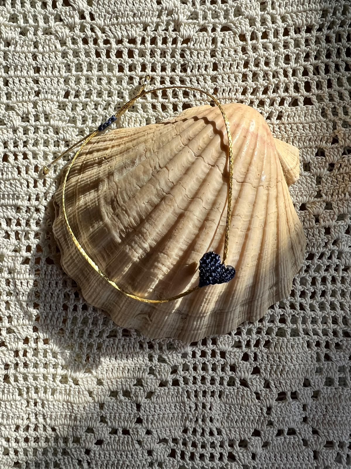 Hand-knotted mirí moró heart on a Mediterranean shell