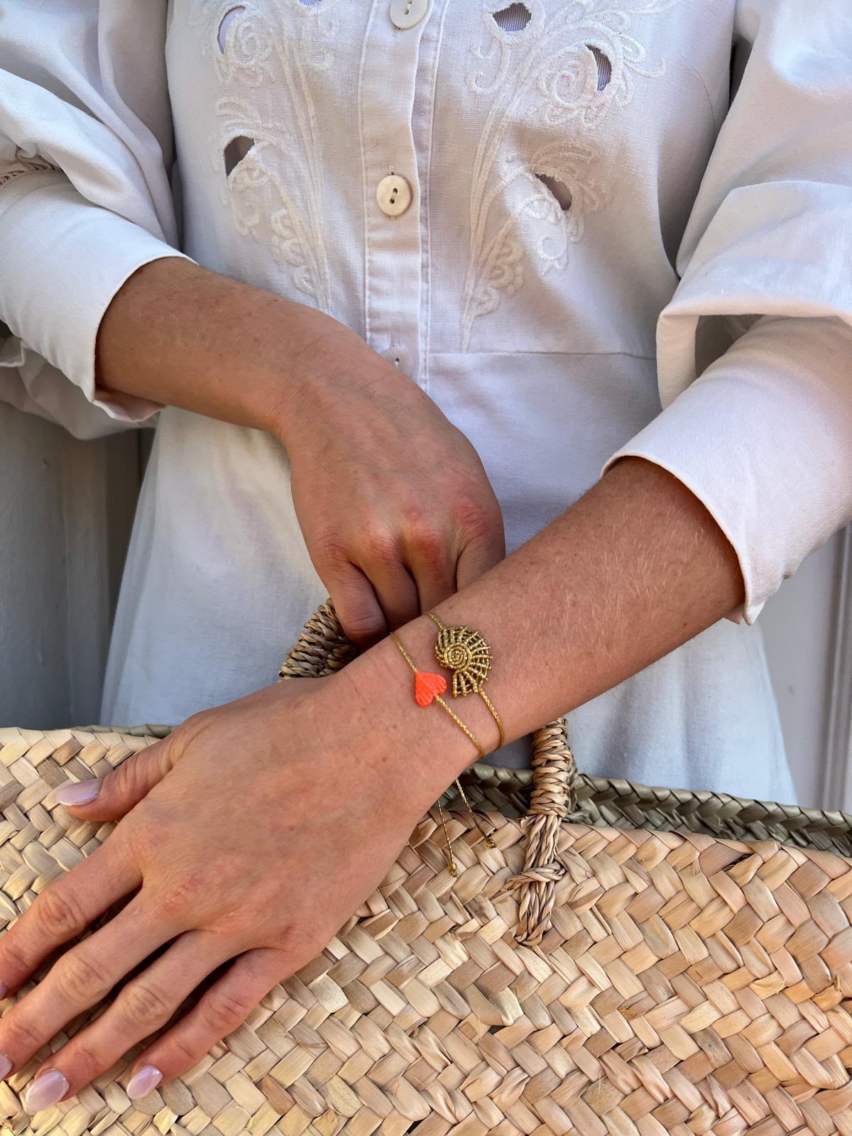 mirí moró gold shell and coral heart bracelets worn on the wrist